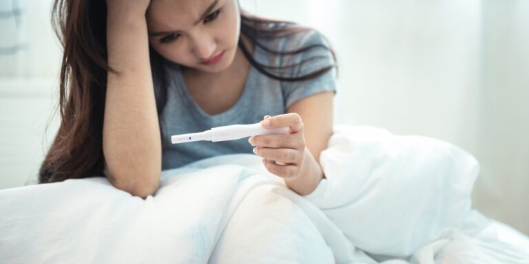 sad woman holding pregnancy test